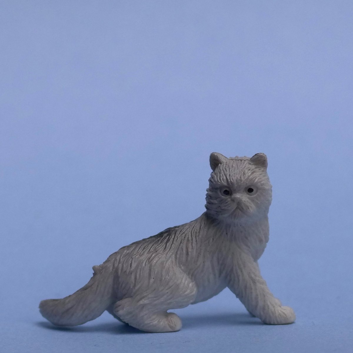 Small cat figurine against a blue background
